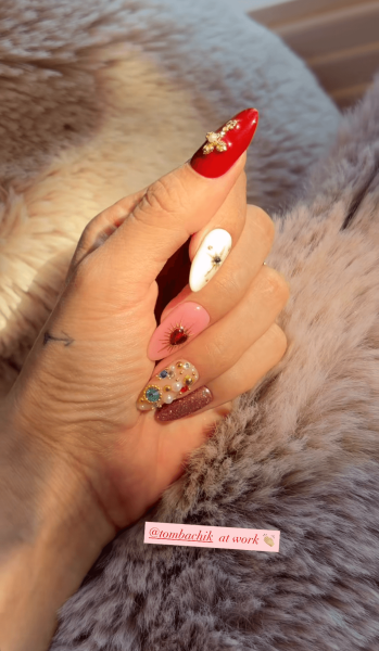 Selena Gomez's hand wearing jeweled icon nail art